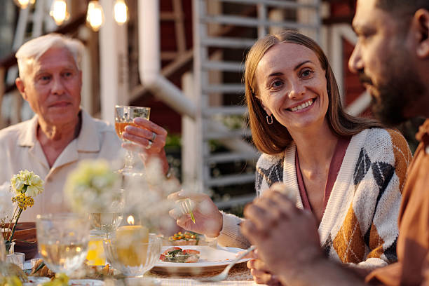 istock Caucasian Woman Smiling While Dining Outdoors with Diverse Friends 2231287763