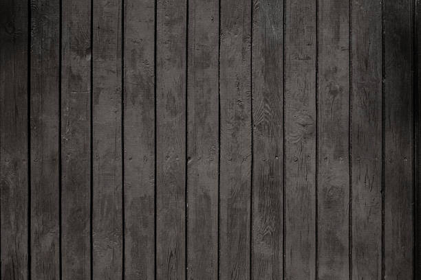 istock Old Rough Wooden Wall Painted Black, Boards Arranged Vertically. 2231292831