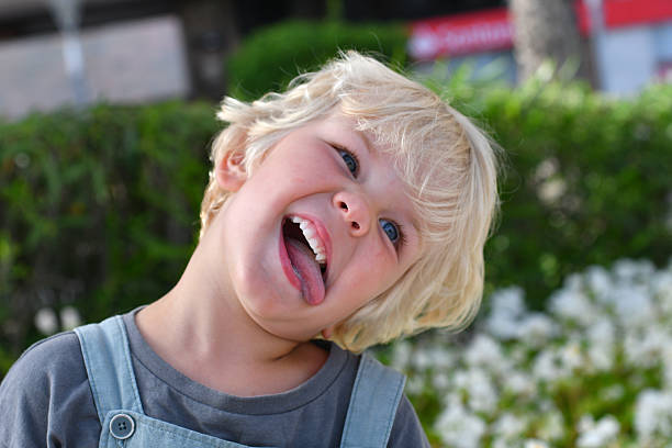 istock Little funny boy making scary grimace face outdoors in summer greenery 2231297477