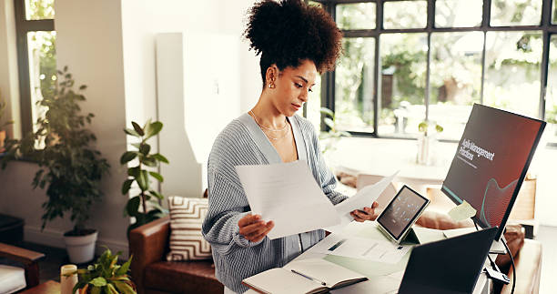 istock Remote work, paperwork and african woman with technology and analysis in home office. Online, research and person reading document for agile management, planning and freelance project at house 2231299833