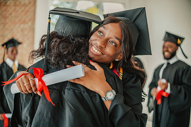 istock Graduation day celebration with young black students joyfully embracing each other on campus 2231304177