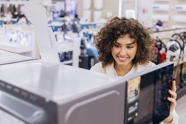 istock Woman Choosing Microwave Oven in Electronics Store 2231304455