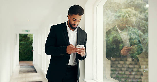 istock Phone, window and businessman in office with communication, networking or email for investment. Cellphone, morning and male financial manager with contact for online finance report in workplace. 2231304502