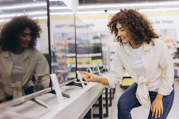 istock Woman choosing new TV in electronics store 2231307172