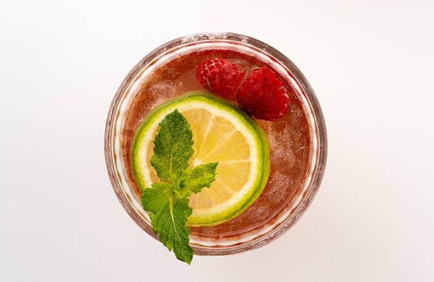 istock Refreshing raspberry cocktail served in a glass, garnished with lime and mint, set against a clean white background 2231308197