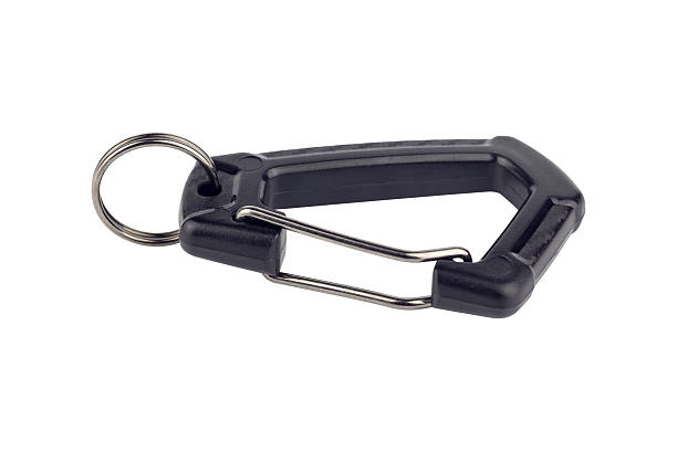 metal carabiners arranged in a straight line on a wooden surface, viewed from above