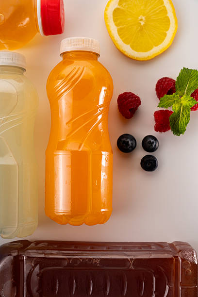istock Different fruit juices in plastic bottles with lemon, raspberries, blueberries and mint on white background 2231313891