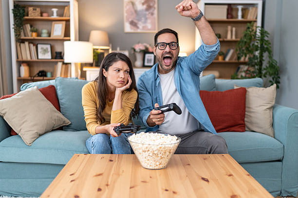 istock Excited man winning at video games while bored woman is losing 2231314909
