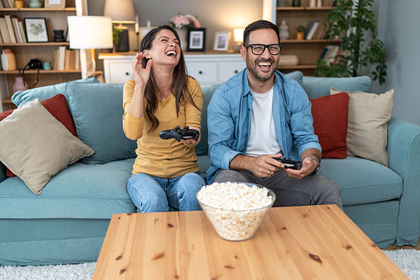 istock Couple laughing while playing videogames at home 2231314980