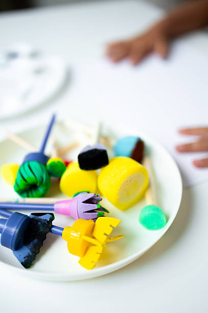 istock Child handcrafting with colorful art tools and clay on plate 2231316575