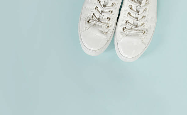 istock Modern white women's sneakers on a light blue background with plenty of copyspace. 2231319754