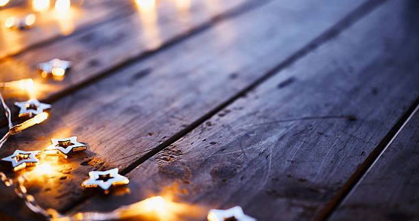 istock Glowing Star-Shaped Fairy Lights on Rustic Wooden Surface in Warm Atmosphere 2231320529