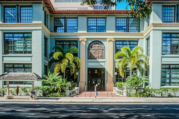 Honolulu, Hawaii, February 23, 2024:  A historic architectural gem in downtown Honolulu, framed by palm trees and classical columns, reflecting the city's cultural legacy.