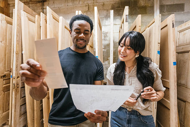 Young couple choosing restored old doors in architectural antiques store