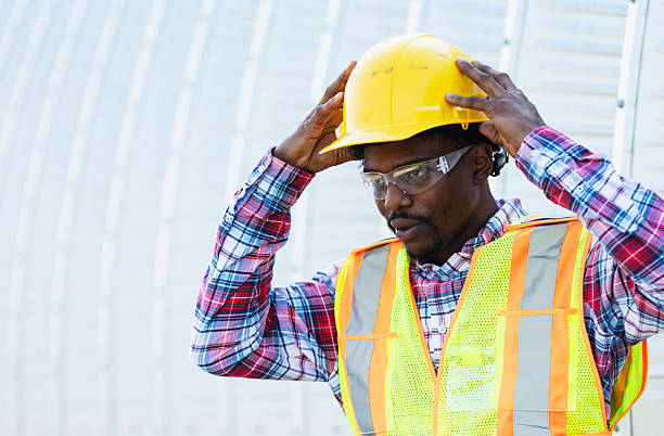 istock African-American construction worker putting on hardhat 2231325034