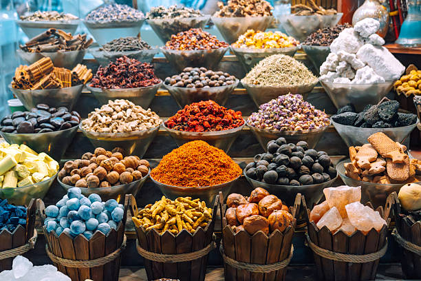 Colorful spices and herbs artfully arranged in bowls, showcasing the rich variety of a local spice market in Dubai. The vibrant arrangement highlights traditional flavors and ingredients from the Middle East.