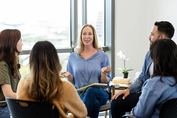 istock Group therapy session: Diverse adults in discussion with therapist 2231325775