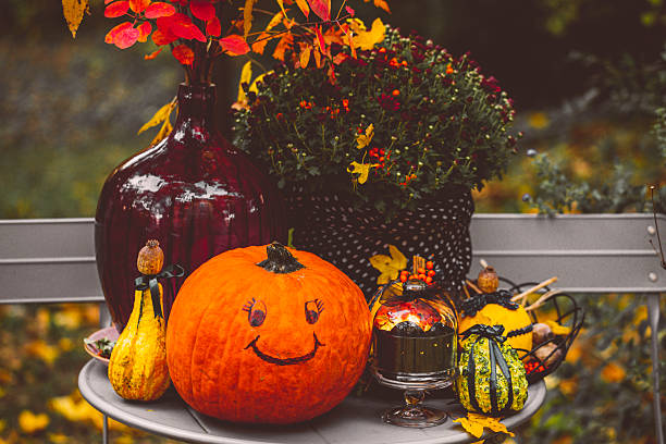 Close up shot of pumpkin Jack-o'-lantern halloween decoration in front of the house above dry hay