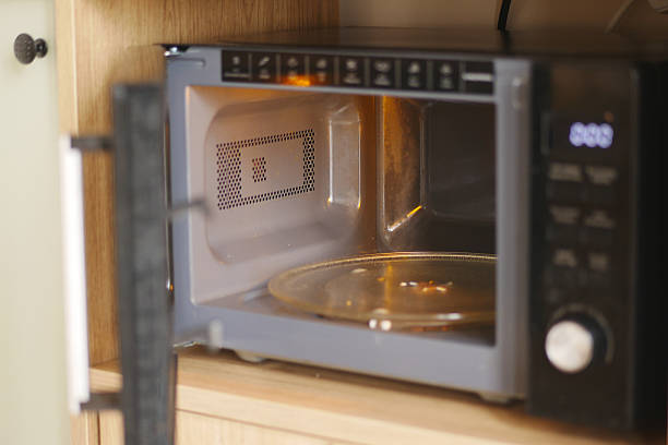 istock Microwave oven on a kitchen counter with an open door 2231341925