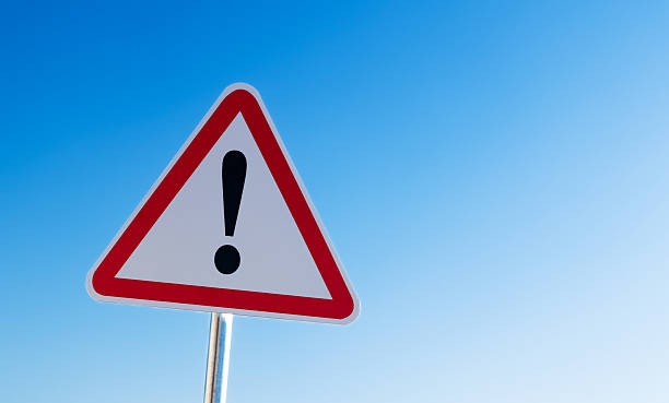 istock Warning sign with exclamation mark isolated on blue sky 2231343120