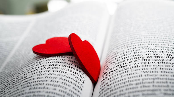 istock Two red heart shapes on an open book 2231343258