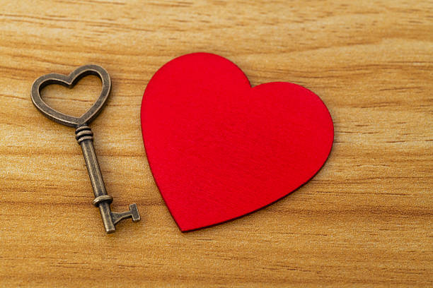 istock Red heart with golden key on the table 2231343371