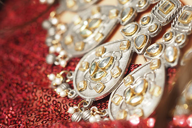 Intricate jewelry gleams against vibrant red fabric at a festive event.