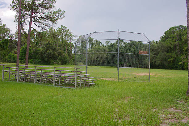 istock Empty Baseball Field With Bleachers Surrounded by Lush Green Grass and Trees. Classic Non urban scene. 2231345447