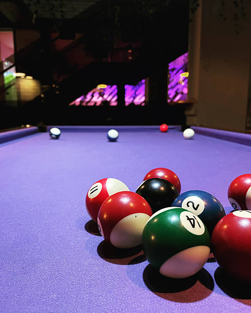 istock Colorful Billiard Balls on Purple Pool Table Under Neon Lights 2231350855