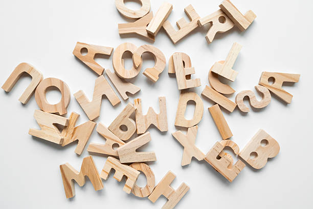 istock Scattered wooden alphabet letters on white background 2231355863