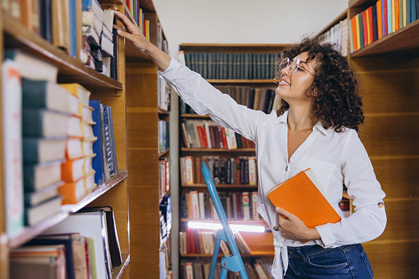 istock Young student searching book in the library 2231360178