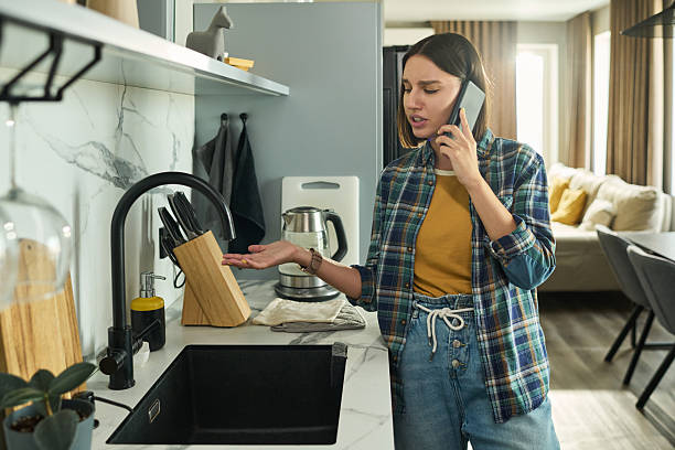 istock Young Caucasian Woman Talking on Smartphone While Gesturing in Kitchen 2231361370