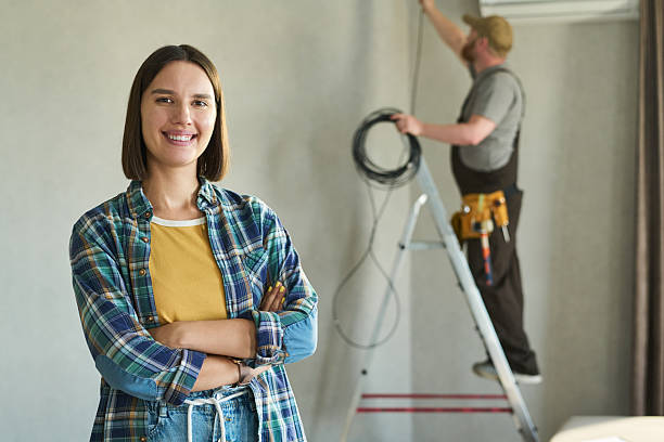 istock Young Caucasian Woman Smiling While Technician Installing Air Conditioner 2231361453