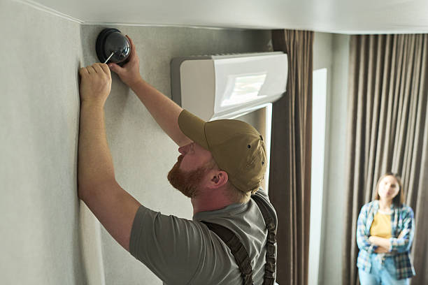 istock Middle Aged Caucasian Man Installing Security Camera While Young Woman Observing 2231361495