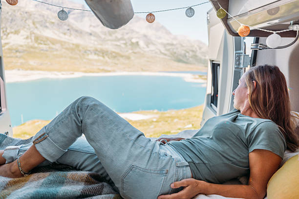 istock Woman Relaxing in Camper Van with Lake View 2231368944