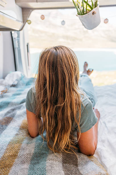 istock Woman Relaxing Inside Camper Van with Scenic View 2231368974
