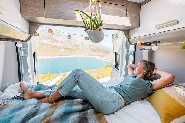 istock Woman Relaxing in Camper Van with Lake View 2231369026