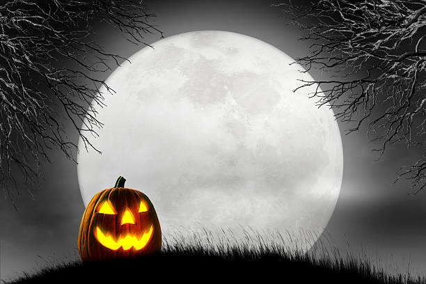 istock Halloween Jack O'Lantern In Front Of Rising Full Moon 2231370855