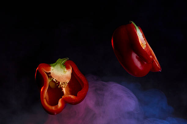 Group of red peppers placed on a black textured surface