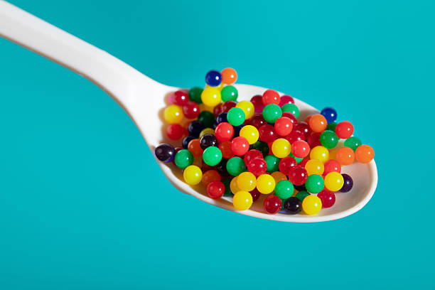 Close-up of a decorative spoon filled with red caviar on a black background