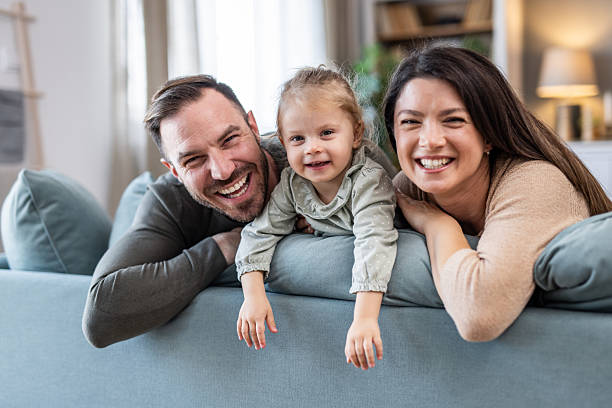istock Happy family smiling and lying on sofa at home 2231385365
