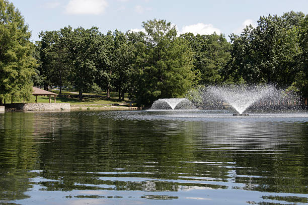 istock Low Angle Pond with Two Fountains and Stone Shelter 2231392180
