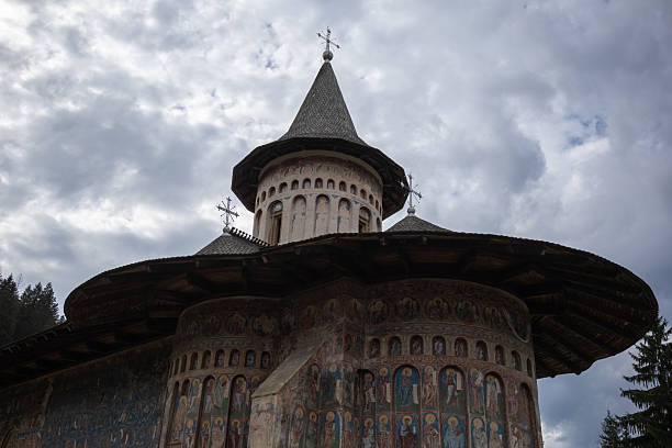 istock detailed low-angle view of a painted orthodox monastery, showcasing its magnificent dome and intricate frescoes under a dramatic cloudy sky 2231392649