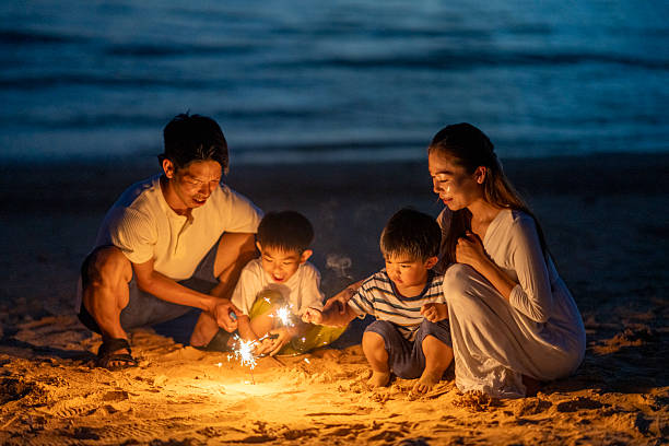 istock Family playing with fireworks on the beach at sunset 2231395639