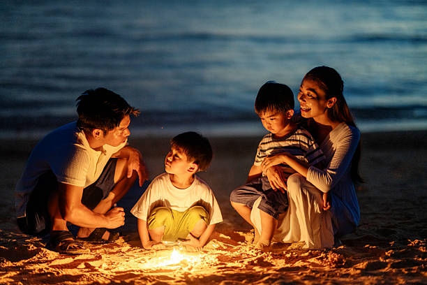 istock Family playing with fireworks on the beach at sunset 2231395641