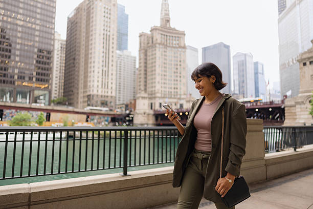 istock Young businesswoman walking in Chicago while using her smartphone 2231400160