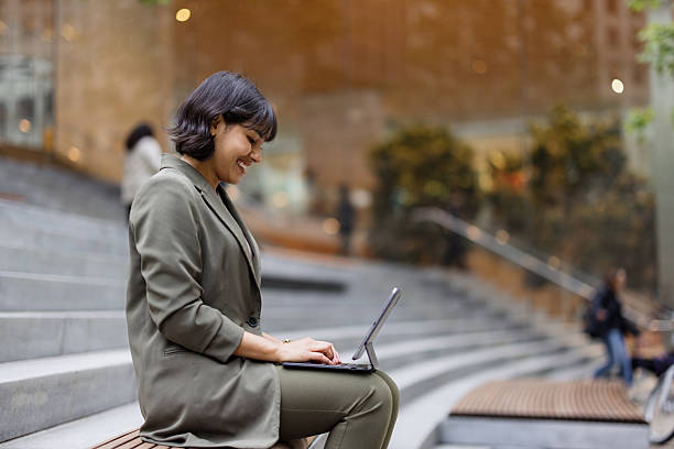 istock Young businesswoman working on tablet in a modern urban setting 2231400171