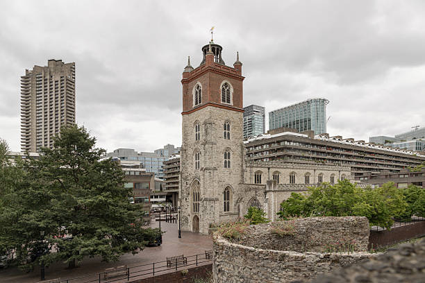 London, UK - Aug 18, 2025 - St Giles Without Cripplegate is indeed situated within the Barbican Estate, near an exposed section of the old Roman wall, a prominent modern development in the City of London. The church, a medieval structure, stands in stark contrast to the surrounding brutalist architecture of the Barbican. use it as your Wallpaper, Poster and Copy space, Select Focus.
