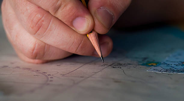 istock Navigator's hand with a pencil over the sea chart 2231403198