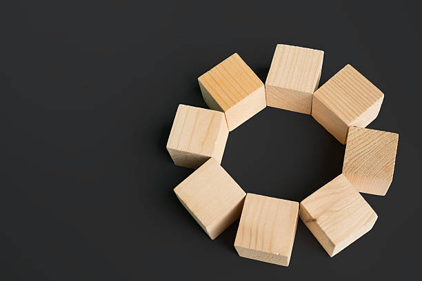 istock Wooden cubes arranged in a circular shape on dark background symbolizing unity, teamwork, and creativity 2231404741